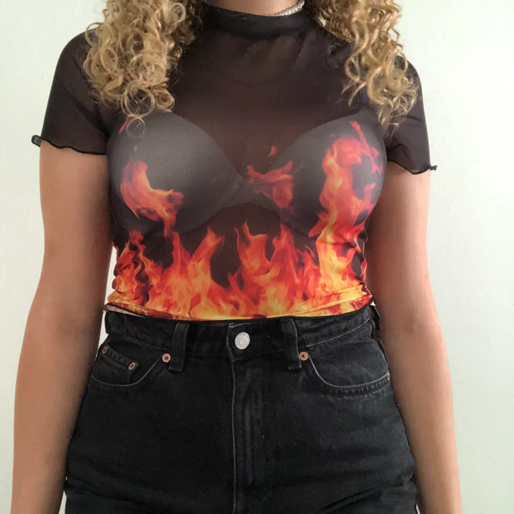 svart mesh T-Shirt från Bershka med eldslågor! storlek S(26) men passar även M. Säljer för att den inte passar min stil :(💘 kontakta mig vid frågor xx. Toppar.