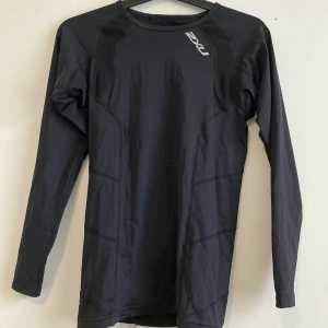 Långärmad träningströja - Oanvänd långärmad träningströja från 2XU. Säljes pga för liten storlek. Köparen står för frakt, kan även mötas upp i norra Stockholm. Hör av er vid frågor! 
