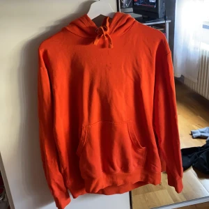 Orange hoodie - Jätte fin färgglad hoodie i bra skick, andvänd några gånger men nästan som helt ny! Säljer pga kommer inte till användning längre. Det är en liten fläck på bröstet men tvättar tröjan innan ja säljer:)