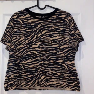 Croppad t-short. Storlek: L - En croppad t-shirt från HM. Aldrig använd. Frakt tillkommer.