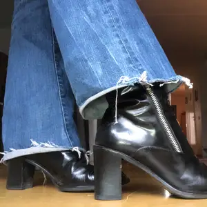Jättefina glansiga svarta klackskor med två dragkedjorna på var sin sida. Går upp en kort bit på benen och passar perfekt till ett par bootcut jeans!💕💕