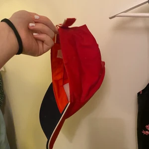 Röd keps - Röd keps med vita och mörklblåa detaljer 