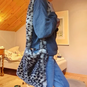Leopard-väska - Jag säljer denna fluffiga leopard-väska. Den liknar de man kan köpa på UNIF. Dessa syns överallt på pintrest och är väldigt fina. Denna är egensydd av mig. På insidan är ett tyg i naturvit. Inuti axelbanden är en rem så att det inte ska töjas ut, men den syns ju inte då den är inuti. BUDA i kommentarerna, avslutas Fredag kl 19.00😌🤎🐆 