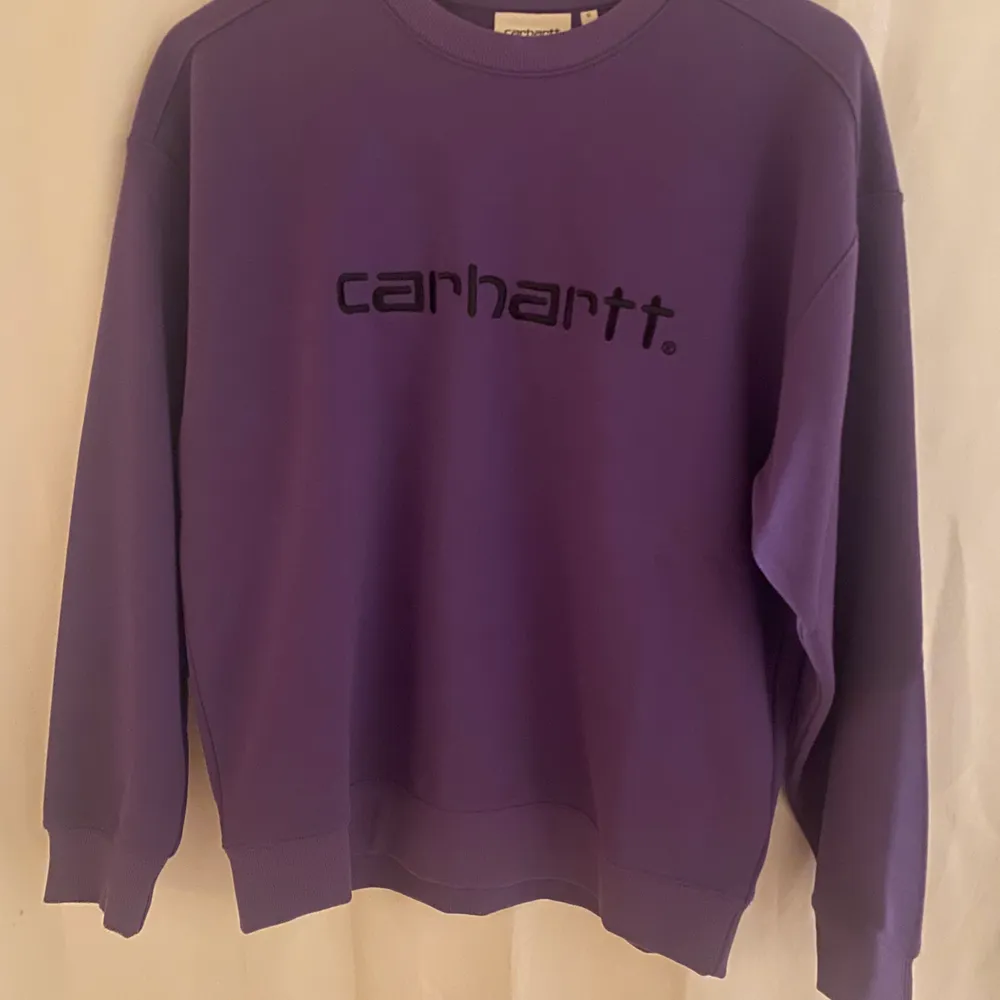 Supersnygg lila Carhartt tröja i Small som sitter lite oversized! Den är väldigt sparsamt använd och nypris ligger på 1130kr❤️🌞. Hoodies.