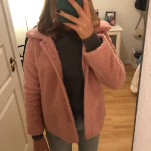 Lindex stl 158 - Märke: Lindex. En härlig rosa färg. Material: Teddy. Köpt från barn avdelningen men passar de som brukar ha XS. Aldrig använd, nyskick. Köpt för 299kr, säljs för 49kr. Frakten står för köparen, köpt är köpt. 
