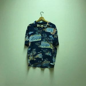 Blå Strand Skjorta - En ball strand skjorta med fina färger. Skit snygg över tex en hoodie eller bara en långärmad tröja:) Köpt på H&M i storlek XL. Använd ett antal gånger och säljer pga att jag aldrig använder den längre.