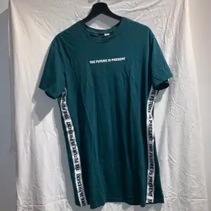 Snygg grön T-shirt med texten ”the future is present” vid bröstet och längst sidorna. Jag älskar färgen på denna tröja men trots det används den inte och därför säljs den. Tröjan är i gott skick och är oversize 