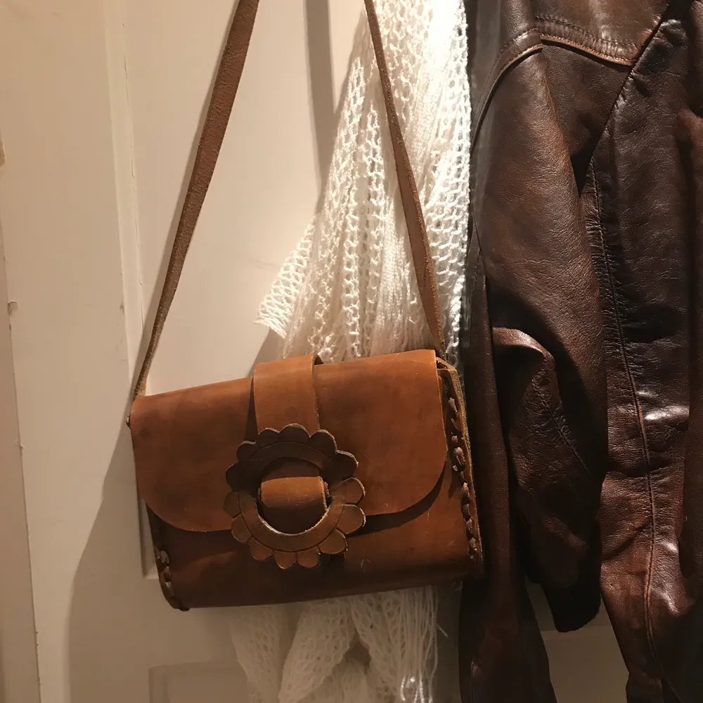 Säljer min bruna läderväska med ett ”blomspänne” 🍁 köpt för typ ett år sedan på en secondhandbutik i Järpen! Kommer tyvärr inte till andvändning längre. 🌼. Väskor.