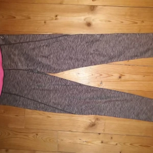 Grå träningstights - Grå-randiga tights med en rosa kant högst upp. Lite slitet där storleken står men annars väldigt bra skick! Stl XS. Frakt tillkommer.