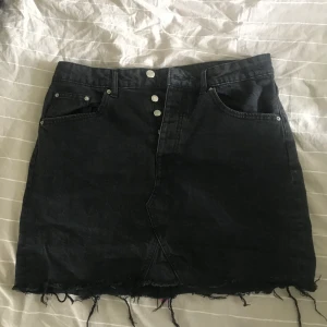 Jeanskjol  - Super fin jeanskjol i en mörkgrå/svart färg med slitningar nertill. Säljer på grund av att den är för stor. Köparen står för eventuell frakt 😄