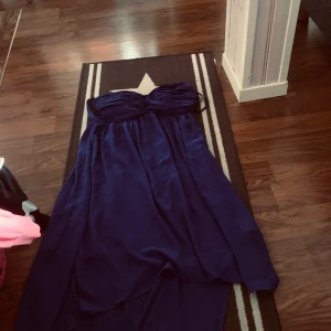 Klänning  - Mörkblå klänning lång bak kort fram använd 1 gång 
