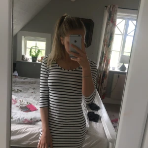 En super skön randig klänning - En vit svart randig klänning från SisterS point i storlek s/m, jag brukar ha xs och det passar mig väldigt bra. Två söta rosetter i ryggen. Använd ett fåtal gånger.