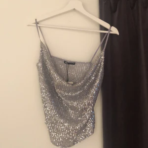Glittrigt linne från zara - Hej jag säljer ett glittrigt linne från zara , aldrig andvänt och prislapp sitter kvar 