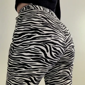 Zebra-byxor  - Croppade zebrabyxor från Motel Rocks. Materialet är som ett tjockare bomullstyg/ tunn denim.  Använda 1 gång. Strl S, midjemått 62 cm längd innerben 65 cm. Frakt 44kr. 