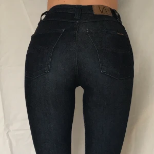 Nudie Jeans, W24 L32 - Superfina Nudie-jeans i mörk denim och ekologisk bomull. Dammodell och smal passform. I gott skick! W24 L32. Kan mötas i Stockholm eller skicka. Köparen står för frakten 66 kr.