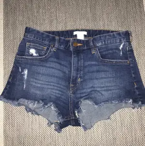 Jeansfärgad Blåa shorts med slitningar lite överallt. Jätte snygga o passar perfekt till sommaren. Storlek 36 men funkar också som en 38. 