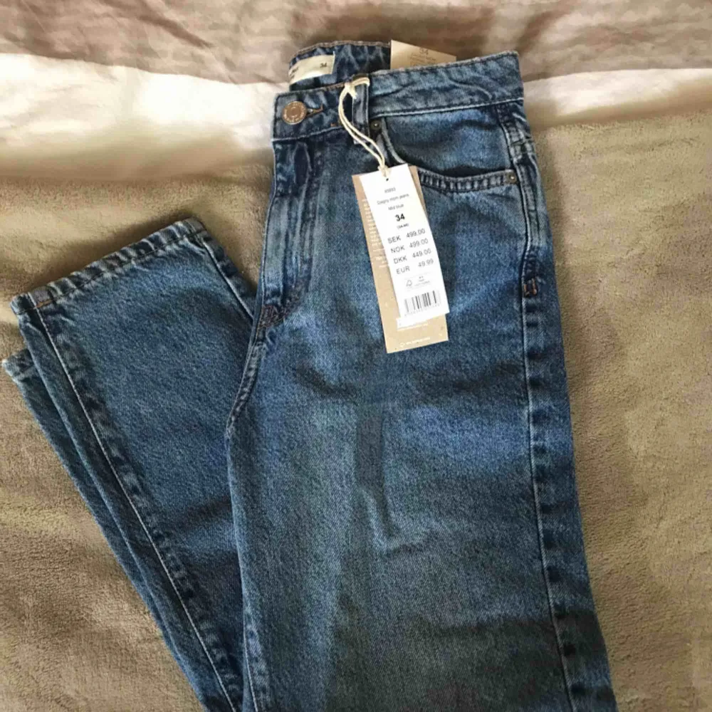 Oanvända Mom jeans från Ginatricot i strl 34. Köpta för 499kr. Säljer eftersom de inte satt bra på mig. Köparen står för frakten😊. Jeans & Byxor.