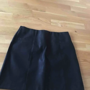  - Kjol i svart imitationsläder från NLY. Aldrig använd och frakt ingår ej! 