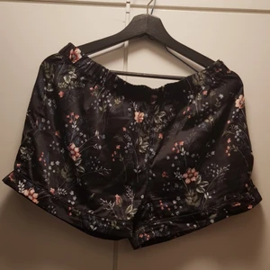  - Pyjamasshorts i mjukt sidentyg, blommigt mönster på svart bakgrund. 