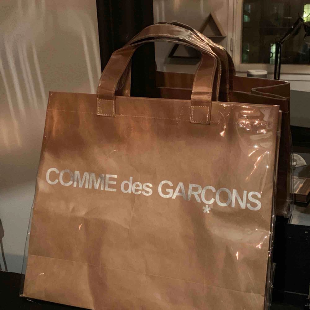 Comme de Garcons paper/plastic tote bag. Ej kommit till användning så inga fel på väskan! . Väskor.