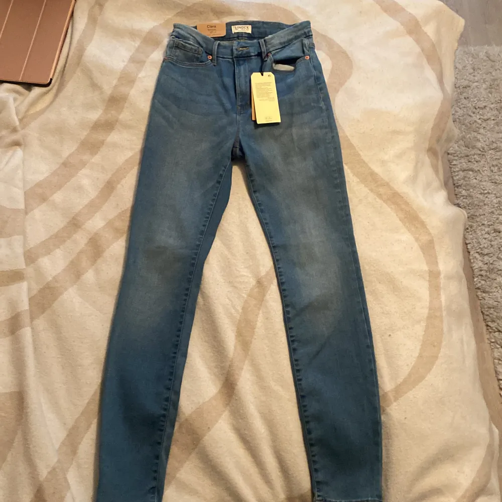 Nyköpta, helt oanvända jeans ”CLARA” från Lindex. Storlek 38, lite osäker på mått men den anpassar sig efter sin kroppsform. Inköpspris 699 kr. Jeans & Byxor.