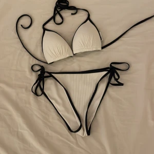 Vit bikini - Vit bikini med marinblåa linjer vid kanterna, köpt på H&M använd två gånger.