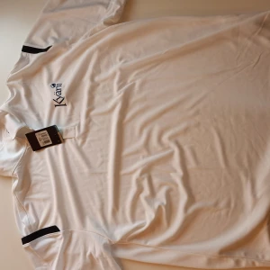 Vit Piké - T-shirt av hög kvalitet, helt ny och fräsch. Både billig och stillig, helt oanvänd.