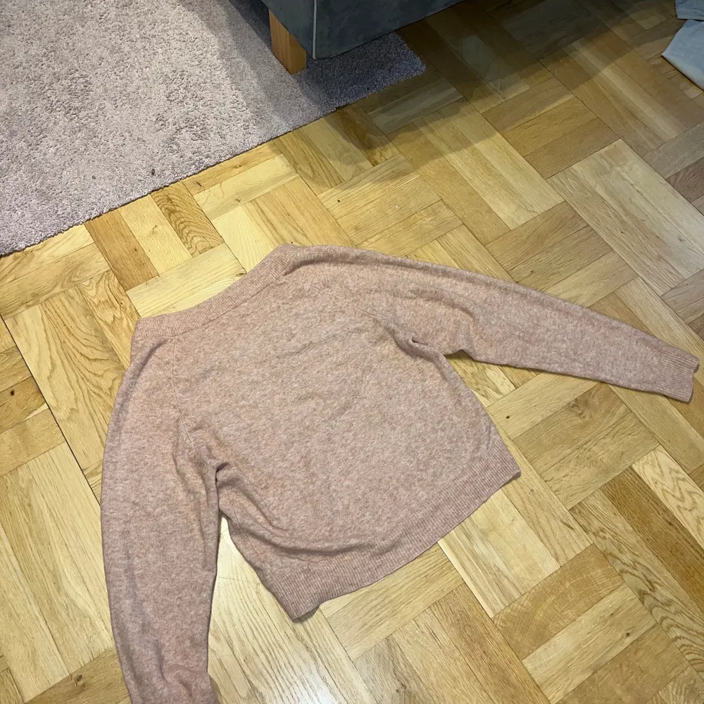 Ljusrosa stickad tröja från Nelly, lite kortare och med v-krage . Neuleet.