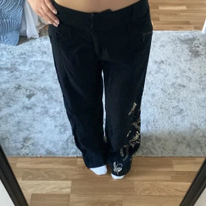 Svarta linnebyxor med broderi  - Jag säljer dessa svarta byxor som är av linnetyg med broderi på ena benet. Säljer dem då de är för långa och har aldrig kommit till användning. Sytt in de lite vid midjan så de sitter bättre. Hör gärna av dig vid frågor💗