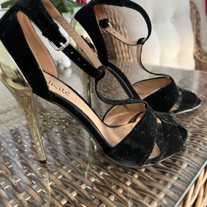 Klackskor  - Klackskor i guld klack med sammet tyg.