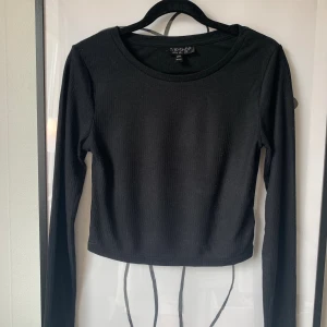 Topp / Croptop - Topshop - Svart långärmad topp från Topshop. Storlek 34 men liten i storleken, skulle också passa en storlek 32. I fint skick 🌸