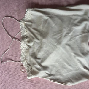Satin-topp  - Säljer denna superfina satintopp i champagne-färg. Unik rygg med tunna snören som korsars i ryggen som är vackert öppen! Aldig använd (prislapp kvar) så väldigt bra skick! Köpt för 280 kr i nypris🙏 postar endast❤️