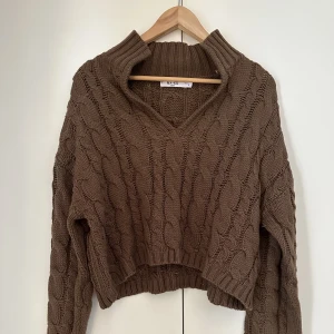 Stickad tröja - Säljer denna helt oanvända kabelstickade koftan från NA-KD. Finns ej kvar på hemsidan köpt ca 2-3 år sen för 399kr säljer för 150kr. Supermjuk o sticks inte alls!! Färgen är som på första bilden. köp via ”köp nu”🤎🤎