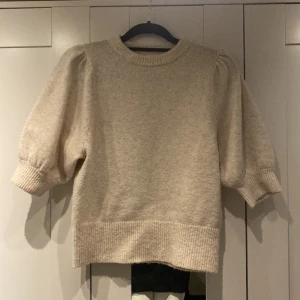 Stickad tröja  - En kortärmad beige stickad tröja från Hm. Knappt använd och som ny.