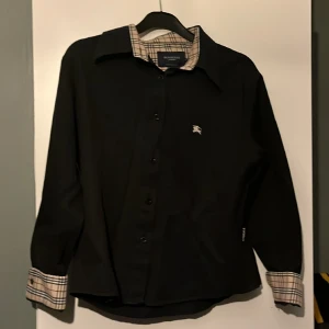 Burbbery skjorta - Släjer nu min sparsamt använda burberry skjorta använda 4-6 tillfällen då jag nu växt ut den lägger jag upp den för försäljning  Hör av er vid funderingar