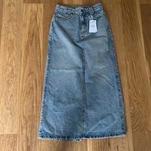 Jeanskjol  - Lång jeanskjol, köpt på STR, storlek 36. Jätte snygg och perfeckt till sommaren. Alldig använd och lappen sitter kvar💕