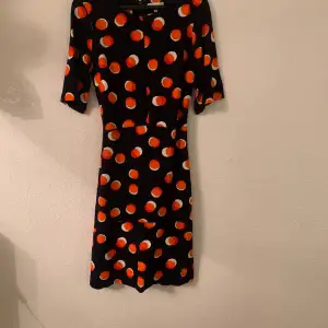 Everyday smart dress. Cotton. Dark blue background with orange and white large dots. Excellent condition. Worn once. Clean. Fitted bodice with slightly flared skirt. 