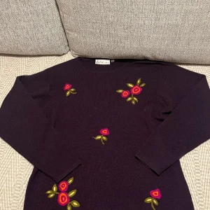 Stickad tröja - Super fin lila tröja med broderade blommor! 30% ull blandning och storlek M. Köpte den second hand men är i väldigt bra skick:)