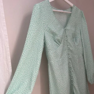 Klänning - Grön klänning med vitt leopardmönster.  Endast testad, skulle säga att den är normal i storleken. Från Nelly x Glamorous kollektionen. Se bild tre för mer exakt färgåtergivning. Nypris 449kr  Priset går att diskutera om det är så💕