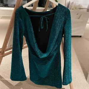 Festklänning - Den perfekta grönskimrande festklänningen säljer jag nu då den tyvärr inte passade i stl… ”Den kända TikTok klänningen” även så kallad!! Superfin öppen rygg med knyte i bak. Långa ärmar med ”bootcut” armar och skimrar jättefint!!💚🤩