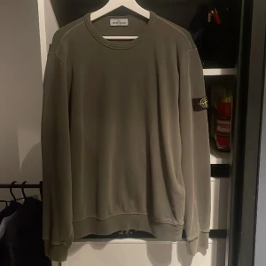 Stone Island Junior tröja - Mörkgrön Stone Island Junior tröja. Storlek 170. Tröjan sitter perfekt på mig och jag är ungefär 173 cm lång. Tröjan är i ett fint skick. Ordinarie pris 2150 kr. Mitt pris 850 kr