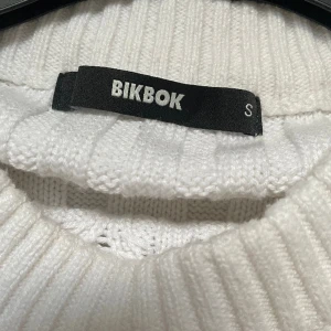 Kabelstickad vit tröja - Kabelstickad vit tröja från bikbok i stl S, det är en väldigt oversized modell. Superfin o bra skick. Frakt är ej inräknad i priset😊