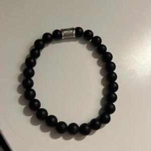 Svart Hugo Boss armband - Ett snyggt svart oanvänt Hugo Boss armband där priset kan diskuteras.