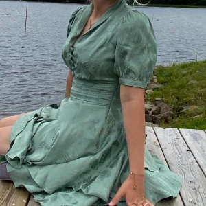 Klänning - Grön kort klänning i satin, superskön och använd fåtal gånger.