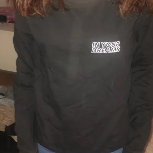 Svart tröja med vit text fram och bak  - En svart tröja med en vit text där fram där de står in your dreams och där bak står de in your dreams fast större och flera gånger och över dår bak står de alvays och under står de forever
