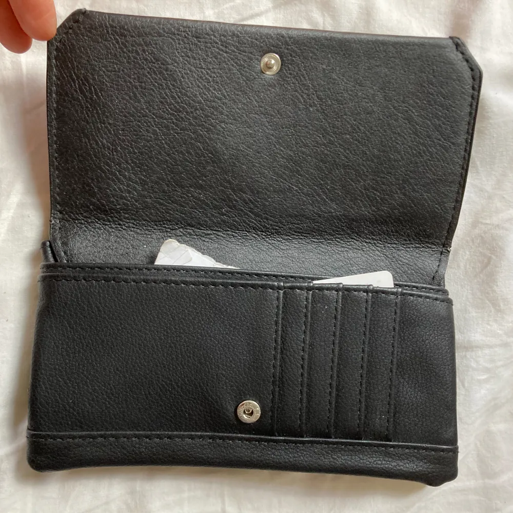 Svart plånbok, aldrig använd . Väskor.