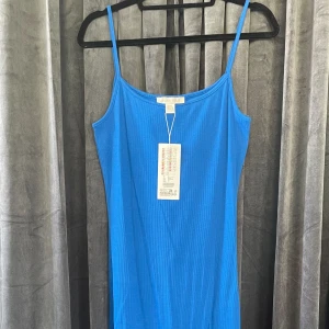 NY ribbad blå klänning - Bara testad en gång, lappen kvar! Slutar typ nedanför knät. 