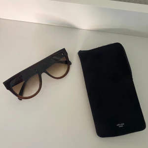 CELINE solglasögon  - Supersnygga solglasögon i en svart/brun färg med sotat glas från Celine!  Köpta i en verifiera vintage butik i Köpenhamn, jag själv har endast använda de två gånger. I mycket bra skick utan repor eller liknande!