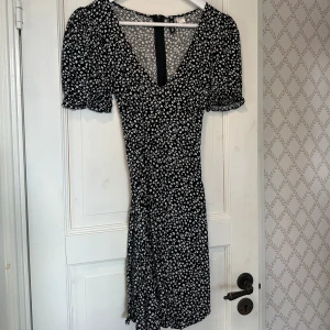 Klänning  - Söt miniklänning med vitt blommönster. Storlek 38, använd vid ett tillfälle.