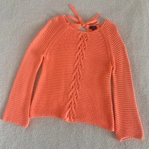 Kappahl korallfärgad stickad tröja med rosett - Magiskt fin stickad tröja från Kappahl i korallfärgad nyans 🪸Vida ärmar och knyts med rosett i ryggen. Köpt för många år sedan. Fint skick, inga noppror etc. Sitter snyggt OZ på mig som är XS/S.